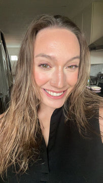 Woman with long hair smiling in a kitchen setting